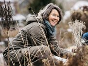 Eine Frau in Hocke in einem winterlichen Garten